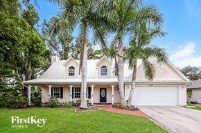 Fort Myers house for rent - a white house with palm trees in front of it