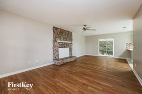 Fort Myers house for rent - a living room with a fireplace and wooden floors