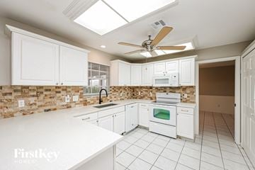 Fort Myers house for rent - a white kitchen with white appliances and white cabinets