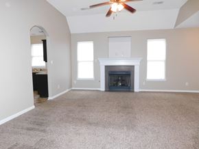 Cordova house for rent - A living room with a fireplace and a ceiling fan.