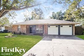 Texas City house for rent - a brick house with two garage doors and a lawn