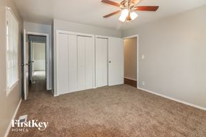 Kansas City house for rent - a bedroom with a carpeted floor and a ceiling fan