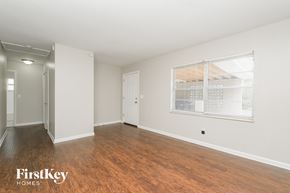 Tampa house for rent - A room with wooden floors and a window with blinds.