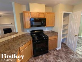 Houston house for rent - a kitchen with a stove and microwave and wooden cabinets