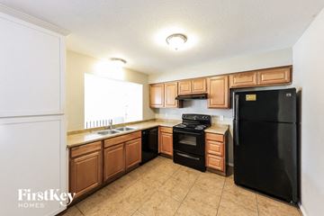 Glendale house for rent - A kitchen with wooden cabinets and black appliances.
