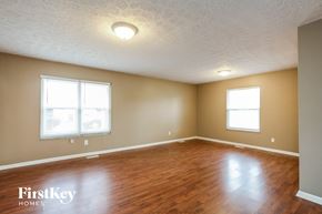 Indianapolis house for rent - the living room of an empty house with wood flooring and two windows