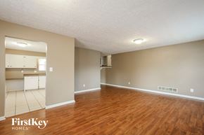 Indianapolis house for rent - an empty living room with wood flooring and a kitchen
