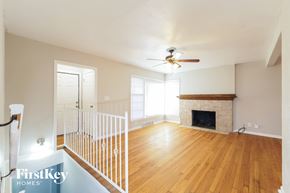 Kansas City house for rent - a living room with a fireplace and a ceiling fan