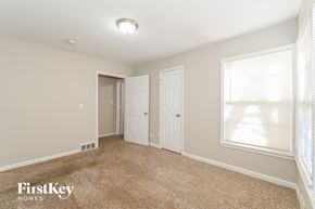 Kansas City house for rent - a bedroom with a carpeted floor and a door to a closet