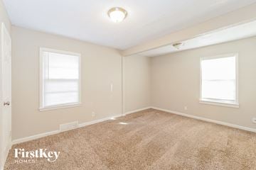 Kansas City house for rent - a spacious living room with carpet and two windows