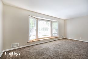 Overland Park house for rent - a bedroom with a large window and a carpeted floor