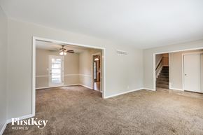 Overland Park house for rent - a living room with a carpeted floor and a ceiling fan