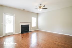 Charlotte house for rent - A room with a fireplace and a ceiling fan.