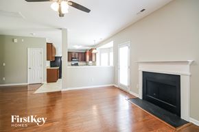 Charlotte house for rent - A living room with a fireplace and a ceiling fan.