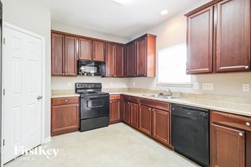 Charlotte house for rent - A kitchen with brown cabinets and black appliances.