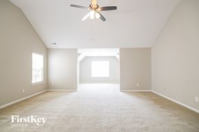 Charlotte house for rent - A spacious room with a ceiling fan and carpeted floor.