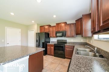 Ruskin house for rent - a kitchen with black appliances and granite counter tops
