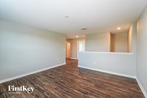 Ruskin house for rent - the living room and dining room of a house with white walls and wood flooring