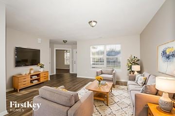 Indianapolis house for rent - A living room with a grey couch, a wooden coffee table, and a painting on the wall.
