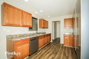 Indianapolis house for rent - A kitchen with wooden cabinets and a granite countertop.
