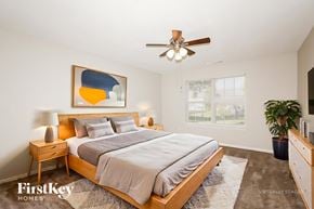 Indianapolis house for rent - A bedroom with a bed, nightstand, and a painting on the wall.