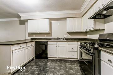 Indianapolis house for rent - A kitchen with a black stove top oven and white cabinets.