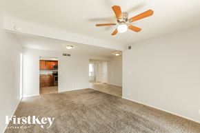 Phoenix house for rent - A spacious room with a ceiling fan and carpeted floor.