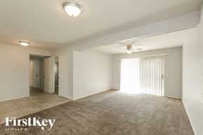 Phoenix house for rent - A spacious room with a carpeted floor and a ceiling fan.
