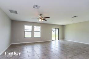 Ruskin house for rent - an empty living room with a ceiling fan and tiled floors