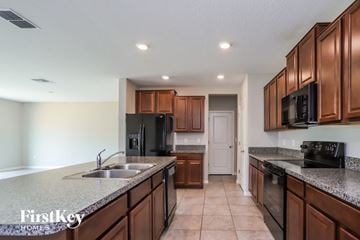 Ruskin house for rent - a kitchen with granite counter tops and wooden cabinets