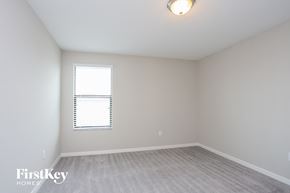 Ruskin house for rent - a bedroom with white walls and a window and a white carpet