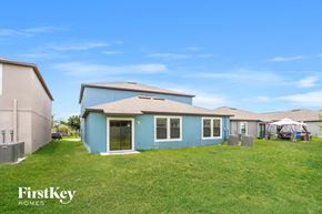 Ruskin house for rent - a blue house with a grassy yard in front of it