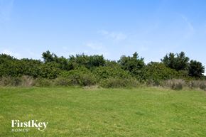 Ruskin house for rent - A field with trees in the background and the words "FirstKey Homes" on the bottom left.