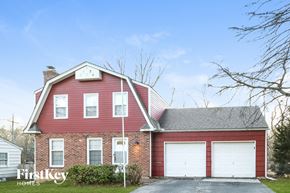 Overland Park house for rent - a red brick house with two white garage doors
