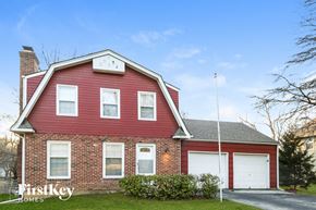 Overland Park house for rent - a red brick house with white garage doors