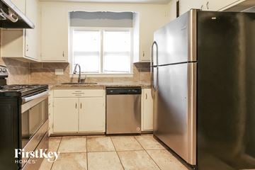 Overland Park house for rent - a kitchen with stainless steel appliances and white cabinets