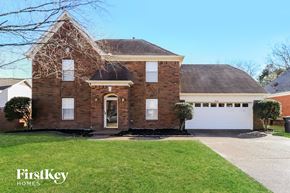 Lakeland house for rent - A brick house with a white garage door and a sign that says FirstKey Homes.