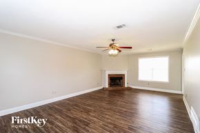 Lakeland house for rent - A spacious room with a fireplace and a ceiling fan.