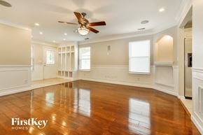 Avon house for rent - A spacious room with wooden floors and a ceiling fan.