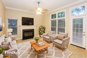 Charlotte house for rent - A living room with a fireplace and a grey couch.