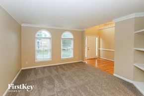 Charlotte house for rent - A spacious room with a carpeted floor and two arched windows.