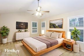 Charlotte house for rent - A bedroom with a bed, dresser, and ceiling fan.