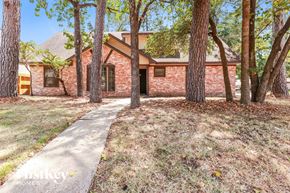 Spring house for rent - a brick house with a sidewalk and trees