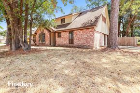 Spring house for rent - a brick house with a yard and trees