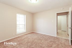 Spring house for rent - a bedroom with carpet and a door to a bathroom