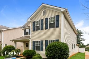 Huntersville house for rent - A house with a beige siding and dark green shutters is for sale.