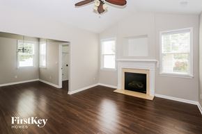 Huntersville house for rent - A room with a fireplace and a ceiling fan.