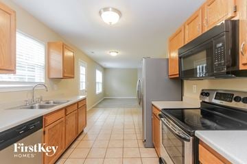 Avon house for rent - A kitchen with wooden cabinets and a black fridge.