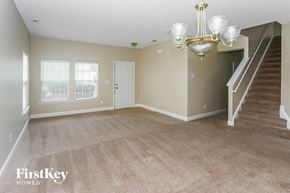 Charlotte house for rent - A spacious room with a staircase and a chandelier.