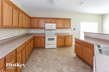 Charlotte house for rent - A kitchen with wooden cabinets and a tile floor.